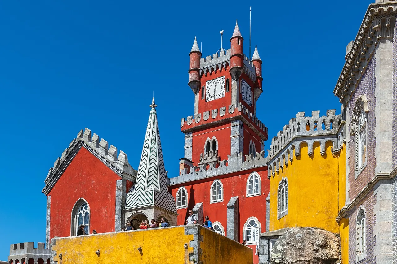 The National Palace of Pena with its yellow and red façades set on the wooded ridge above Sintra