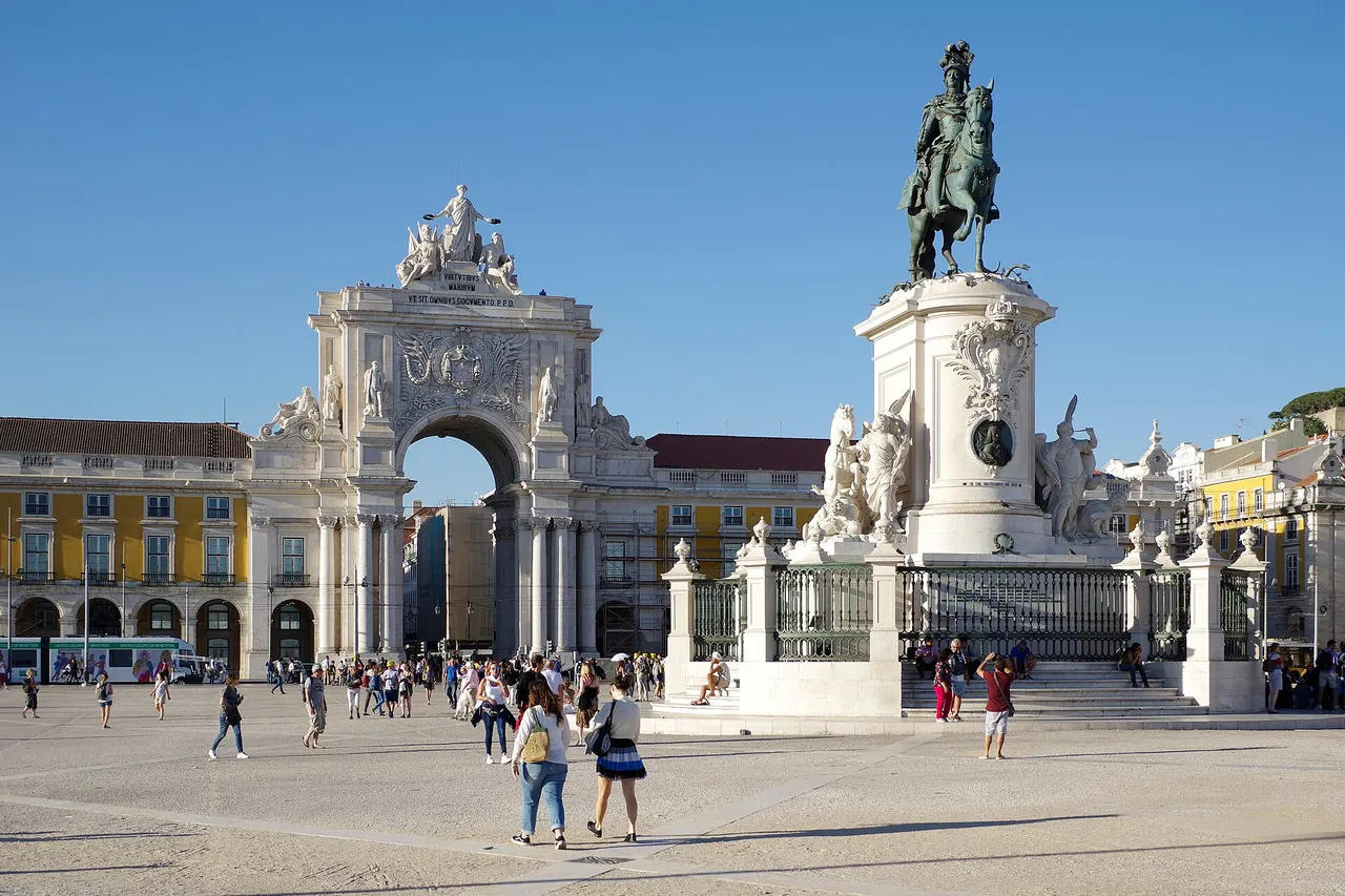 Die Praça do Comércio in Lissabon, ein weiter ebener Platz mit gelben Arkaden am Tejo