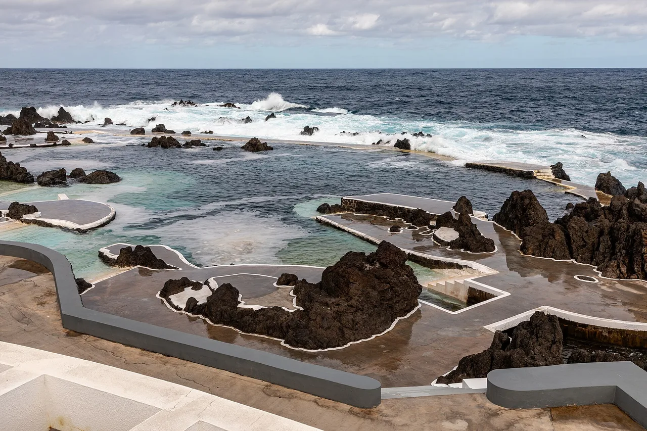 Les piscines naturelles de Porto Moniz entre les rochers de lave noire, avec les vagues au fond