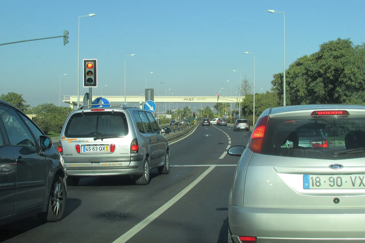 Una fila de coches con matrícula portuguesa detenidos en un semáforo de la nacional 125, en el Algarve
