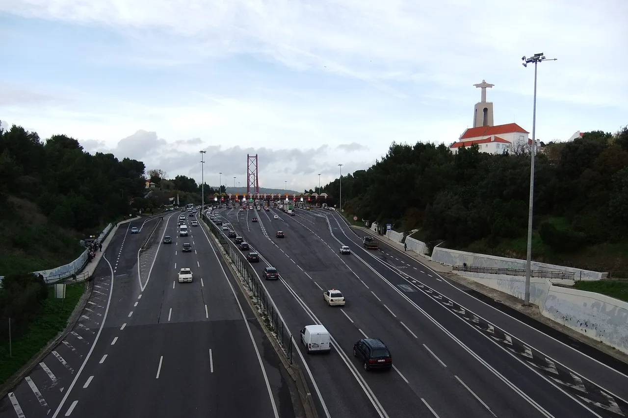 La avenida de acceso al puente 25 de Abril de Lisboa, con el puente al fondo y el Cristo Rei a la derecha