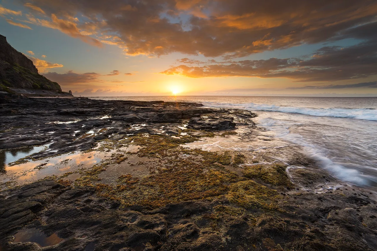 La pointe rocheuse du Cap La Houssaye au coucher du soleil, à Saint-Paul, La Réunion