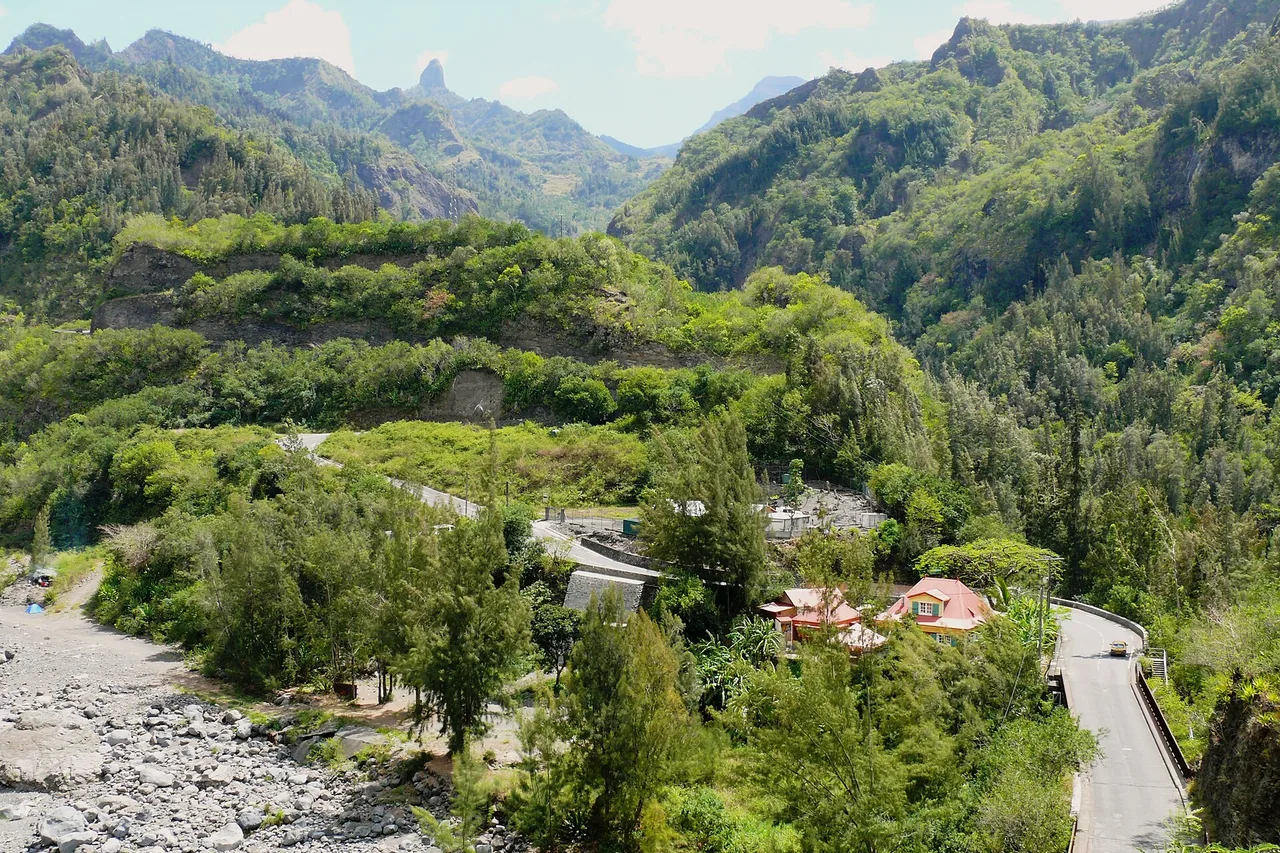 Die Straße nach Cilaos mit ihren Serpentinen im Talkessel, zwischen Felswänden und kreolischem Haus, La Réunion