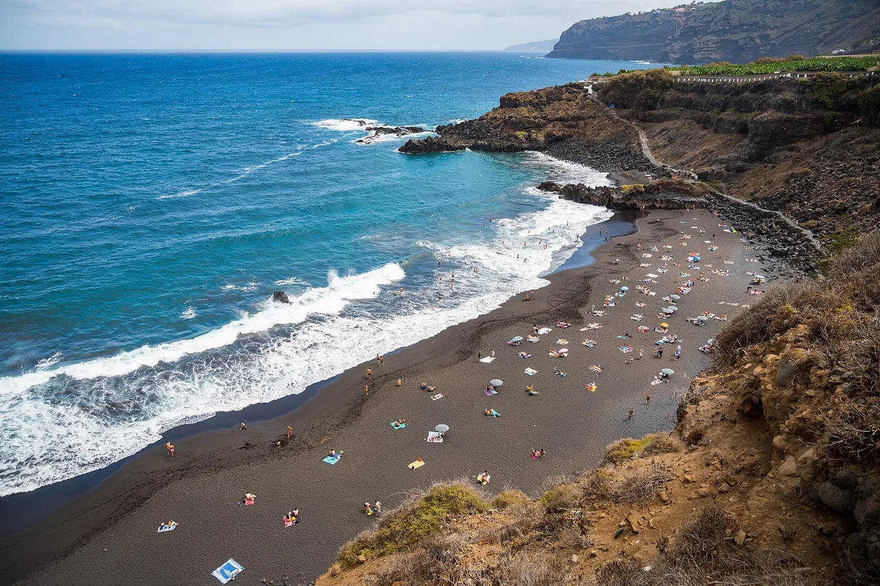 Die schwarze Sandbucht El Bollullo mit türkisfarbenem Wasser von der Klippe aus, Teneriffa