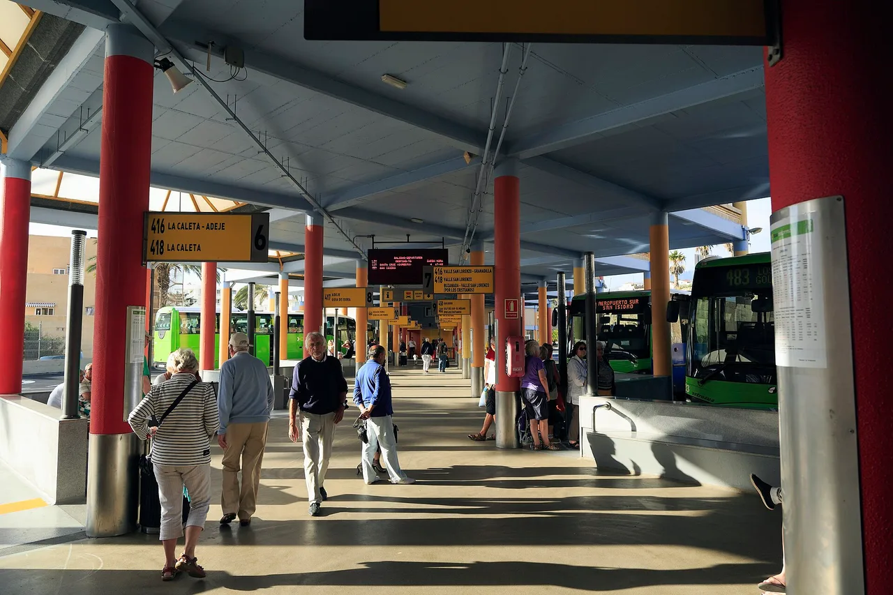 Reisende mit Koffern am Busbahnhof Costa Adeje auf Teneriffa