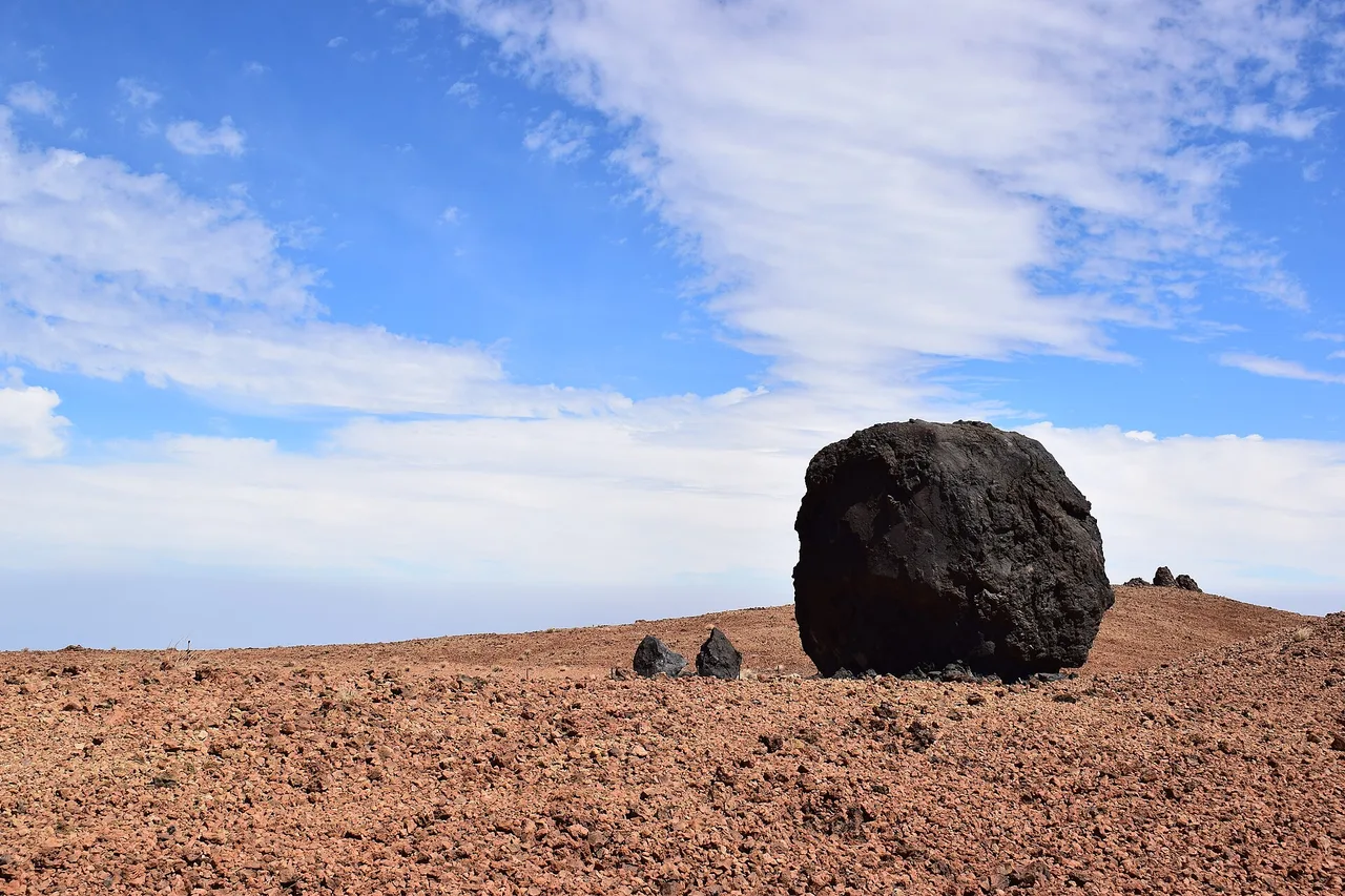 Un « œuf du Teide », boule de lave noire posée sur les pentes ocre de Montaña Blanca, Tenerife