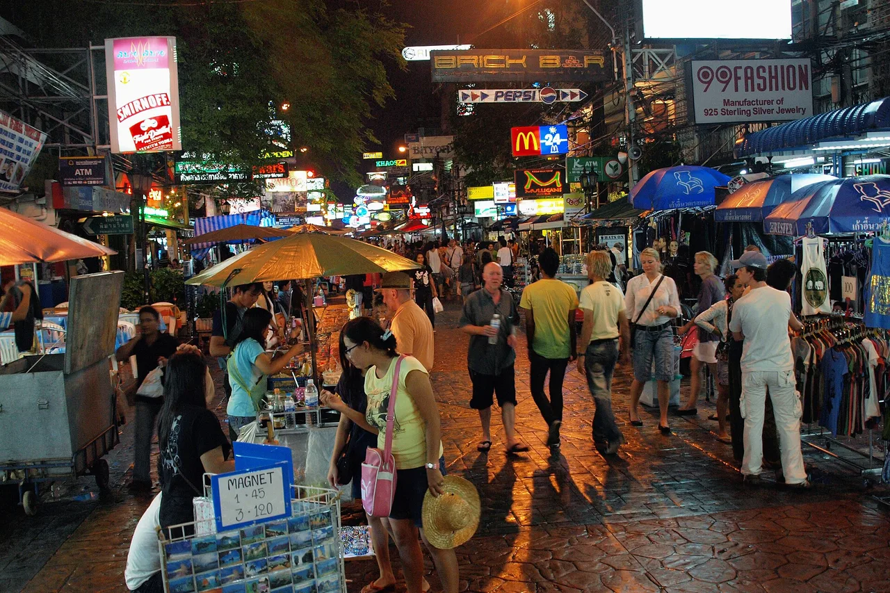 La foule et les enseignes lumineuses de Khao San Road en soirée, Bangkok