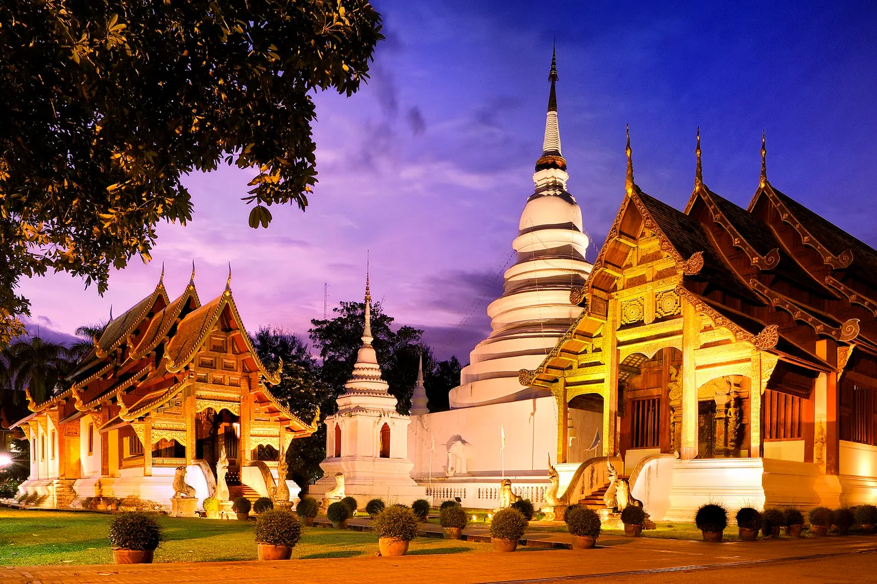 Der Tempel Wat Phra Singh in Chiang Mai in der Dämmerung beleuchtet, unter violettem Himmel, Thailand