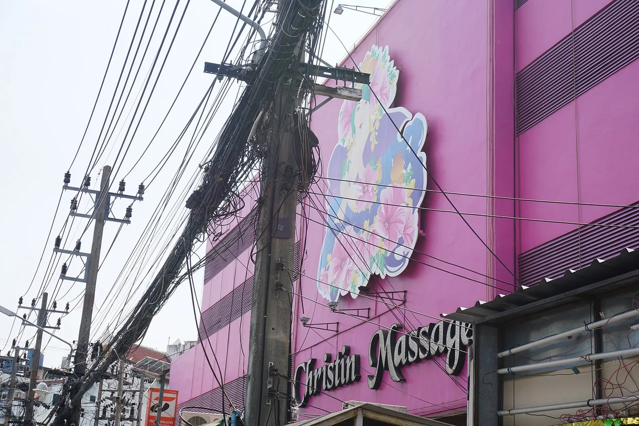Schild eines Massagesalons und Kabelgewirr in einer Straße von Patong, Phuket