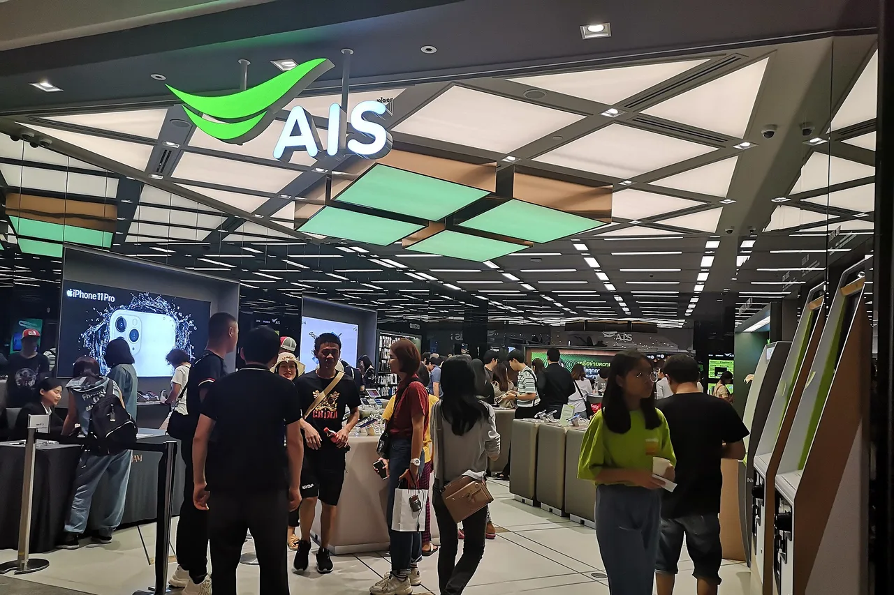 Boutique AIS dans un centre commercial de Bangkok, enseigne verte et clients au comptoir