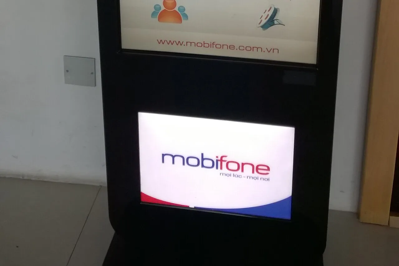 Borne d’information MobiFone en format vertical à l’aéroport de Noi Bai, à Hanoï, avec enseigne lumineuse et brochures