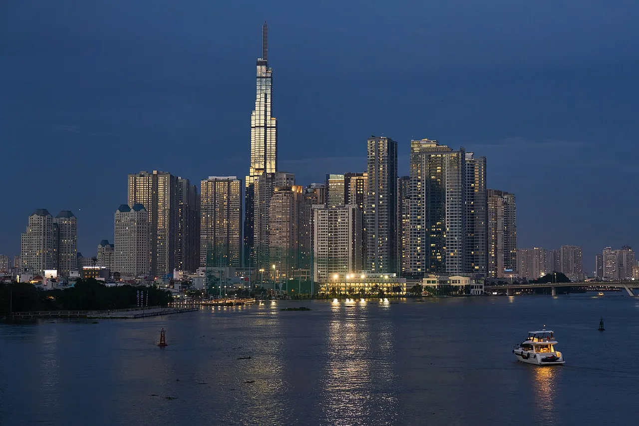 Die beleuchteten Hochhäuser von Ho-Chi-Minh-Stadt mit dem Turm Landmark 81 am Ufer des Saigon-Flusses in der Dämmerung