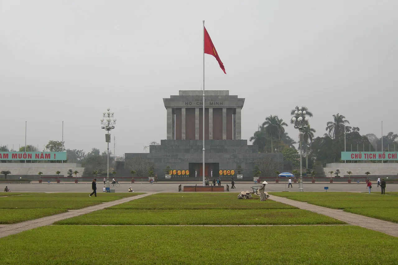 Le mausolée de Hô Chi Minh en pierre grise au bout de la vaste place Ba Đình, avec pelouses et mât de drapeau