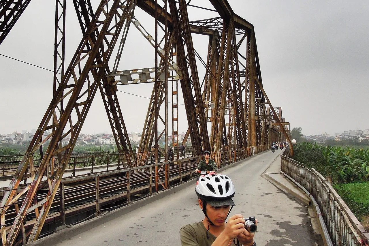 Le pont métallique rouillé Long Biên, avec sa voie étroite pour les deux-roues, au-dessus du fleuve Rouge