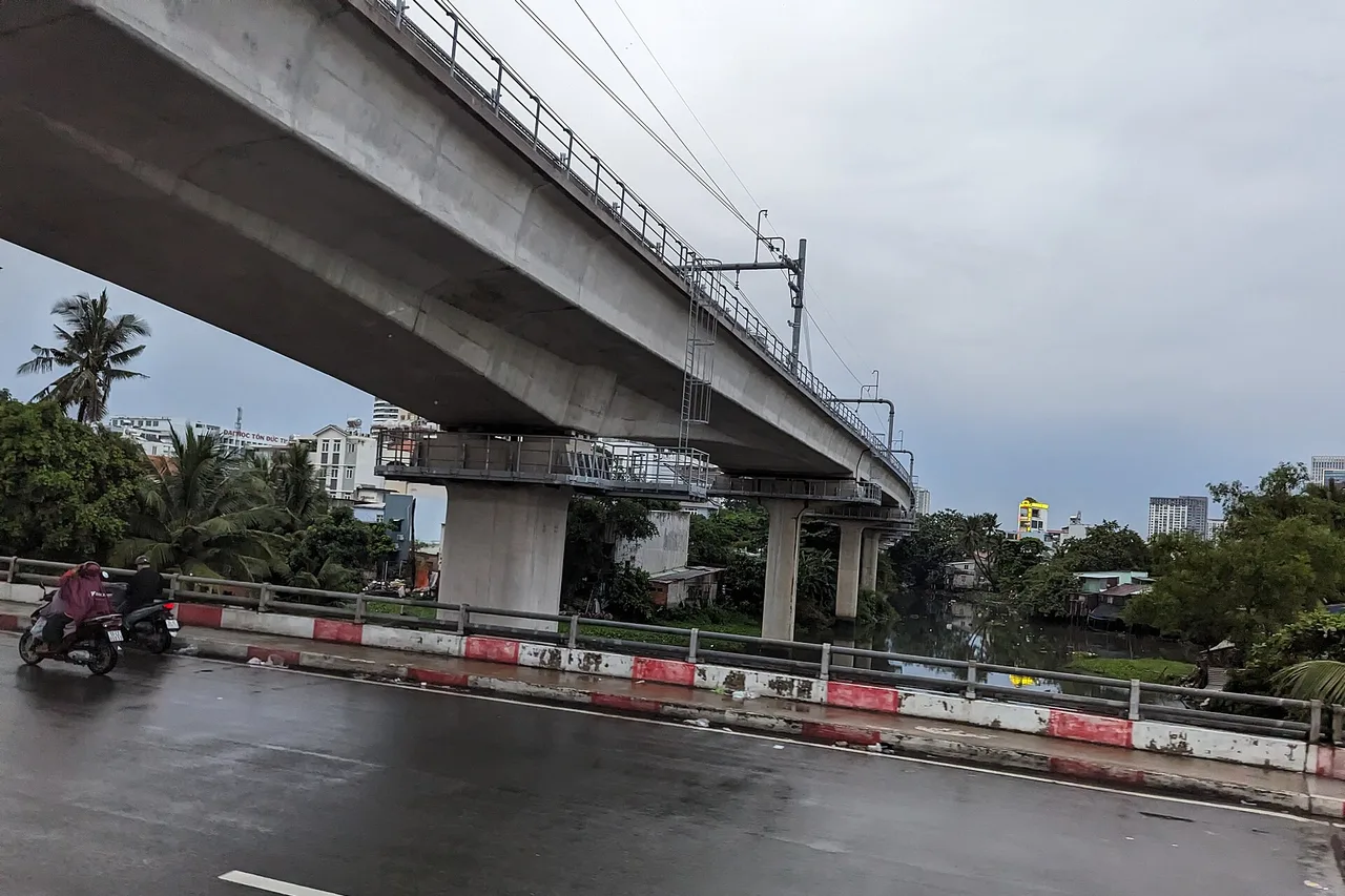 Rue mouillée sous un viaduc de métro à Saïgon, par temps de pluie et ciel gris